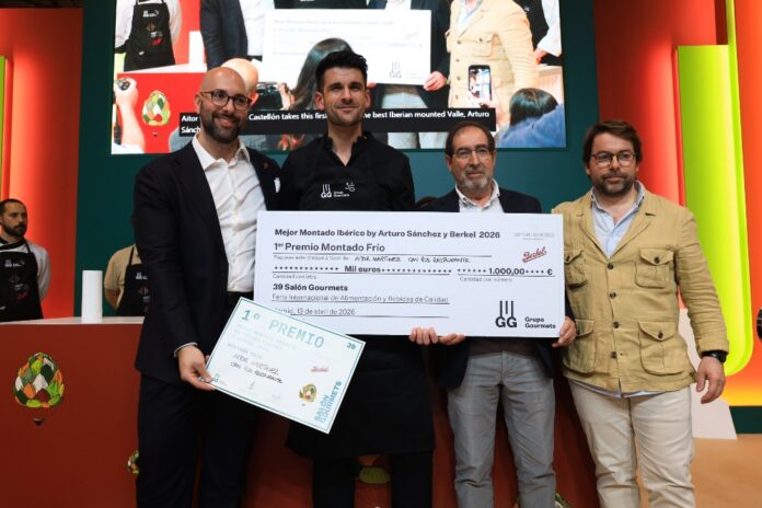 Group of four men on stage holding a large ceremonial check and a certificate during an awards event.