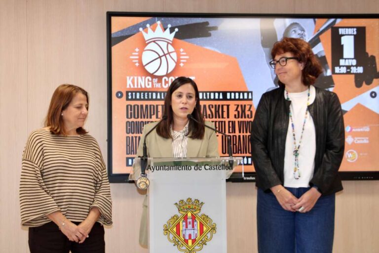 Three women stand at a podium labeled Ayuntamiento de Castellón during a press conference, with a large orange poster on a screen behind them.",