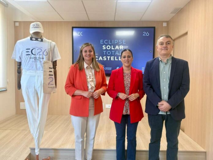 Three people stand in a light wood–paneled room beside a life-size white mannequin and a screen that reads 'Eclipse Solar Total Castello'.