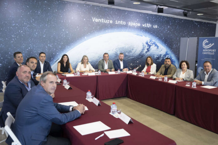Group of professionals seated around a U-shaped table in a conference room with a space-themed backdrop reading 'Venture into space with us'