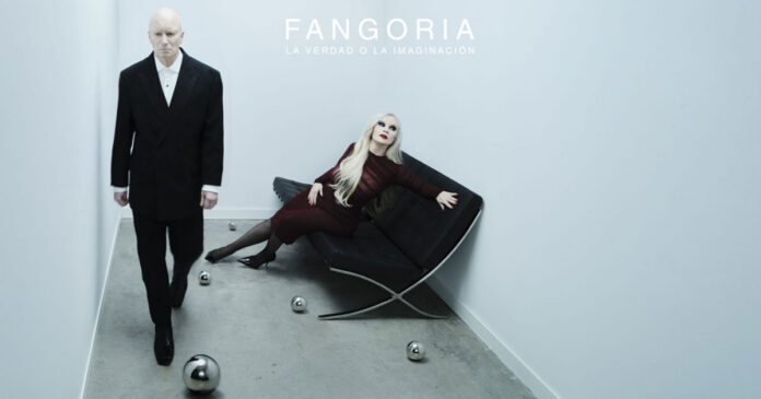 Fangoria magazine cover: a man in a black suit stands in a white room while a blonde woman in burgundy reclines on a black chair at the center top reads ‘FANGORIA’.
