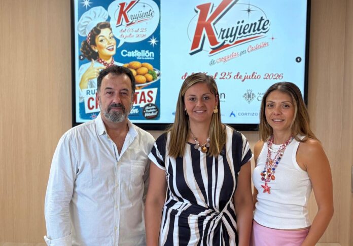 Three adults smiling at the camera in front of a promotional poster on a wall.