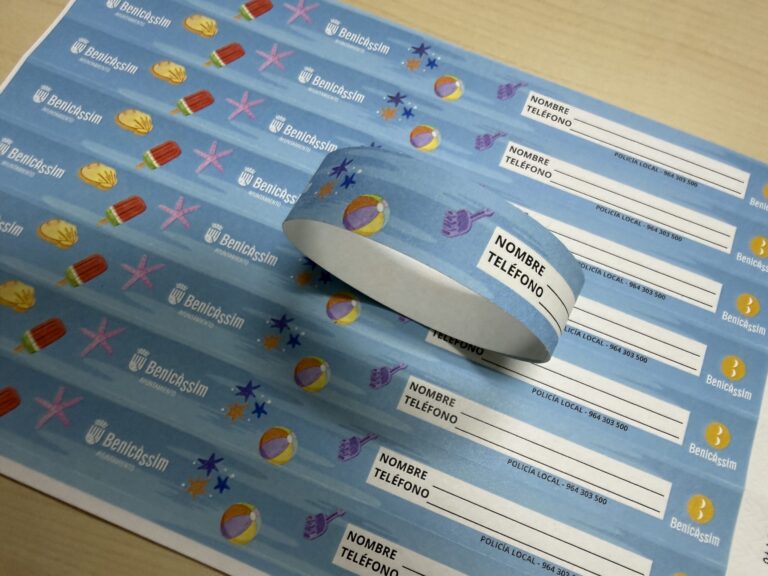 Blue Benicàssim forms for recording name and phone number, with a curved sheet resting on top and summer stickers in the background.